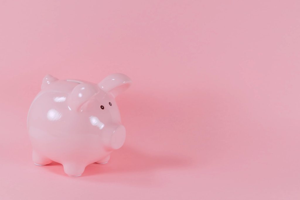 Alcancía de marrano sobre fondo rosa: El reto de las 52 semanas, un buen método para ahorrar dinero