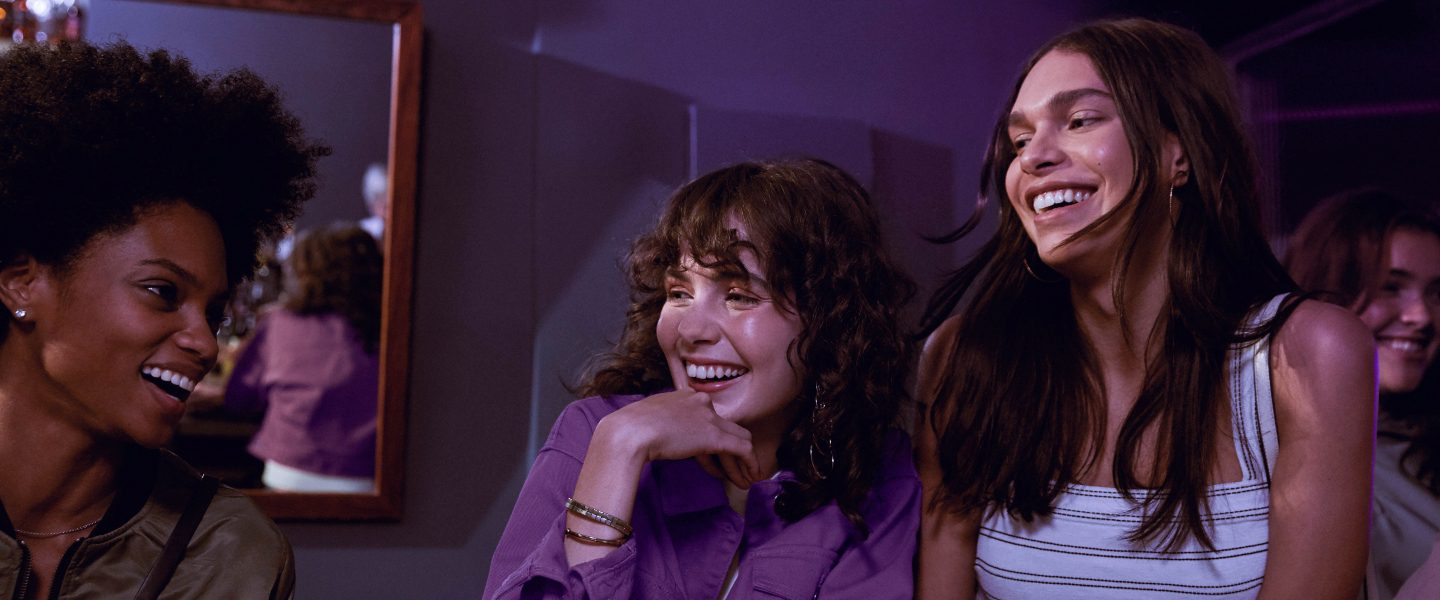 Nubank supera los 35 millones de clientes en menos de siete años. Foto de amigas riendo en un bar. Nubank supera los 35 millones de clientes en menos de siete años.
