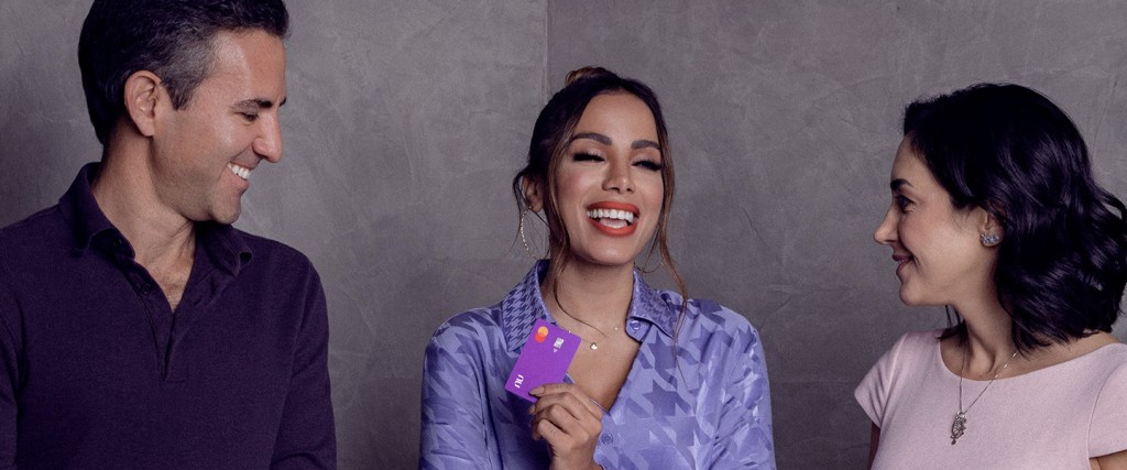Anitta es la nueva miembro del Consejo de Administración de Nu Foto de Anitta con David Vélez y Cristina Junqueira sonrientes con la tarjeta de crédito de Nu.