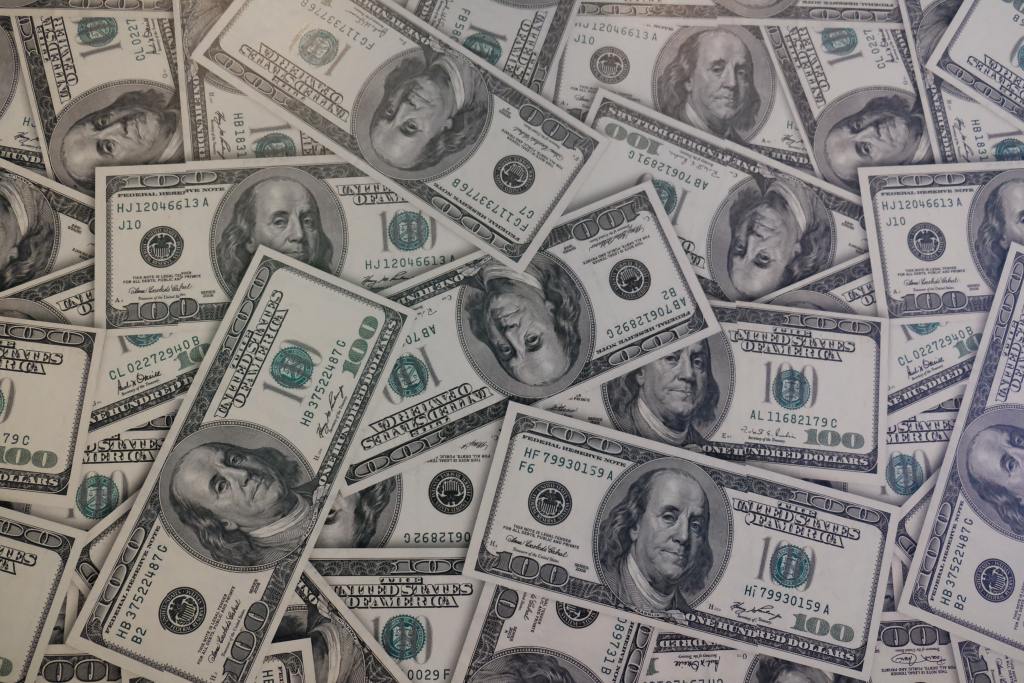 Imagen de billetes de cien dólares estadounidenses. ¿Por qué sube el dólar en Colombia?