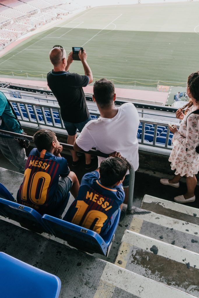 Foto de dos niños en el estadio con la camiseta del Barça con el dorsal 10 y el nombre de Messi.