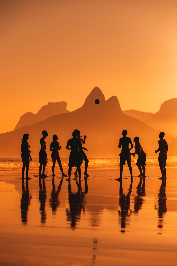 Foto de amigos jugando futbol en playa de Río de Janeiro: Brasil, el mayor exportador de jugadores.
