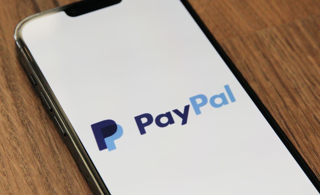 Foto de celular con el logo de PayPal que es un servicio de pagos en línea. Medios de pago.