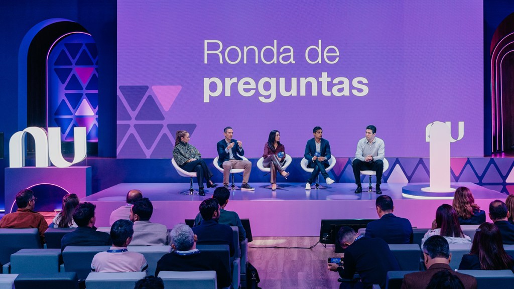 Las preguntas a nuestros líderes, en Nu con los medios. Líderes de Nu en un escenario reunidos sentados. Atrás una pantalla que dice ronda de preguntas