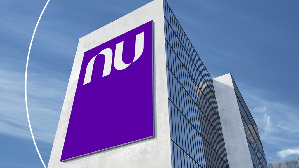 Nu Holdings vuelve a registrar utilidad récord: Conoce los resultados del 3er trimestre de 2023 Foto de una torre de oficinas con un banner morado y el logo de Nu impreso en este