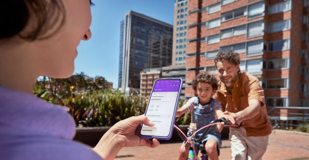 Foto de padres felices con su hijo en la bici y tranquilos porque tienen la Cuenta de ahorros Nu.