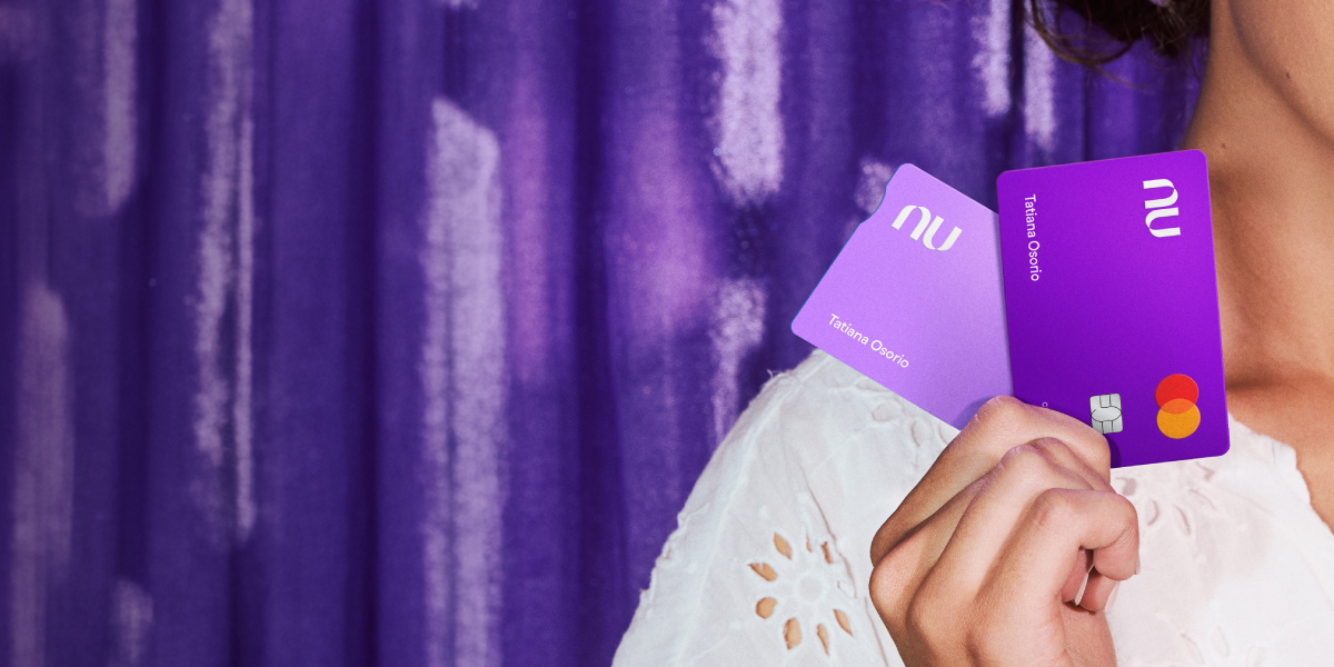 Blog_MacroBlog Beneficios_HEADER Conoce los beneficios que tienes por ser parte de Nu, así como las funcionalidades que tienes disponibles para mover tu dinero | mujer sosteniendo Tarjeta de Crédito y Débito Nu.