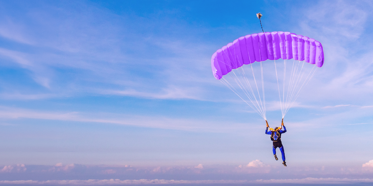 ¿Cuánto te cuesta practicar deportes extremos? Persona en un parapente morado. ¿Cuánto te cuesta practicar deportes extremos?
