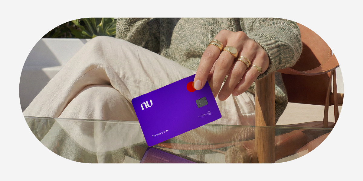 Foto de persona con la tarjeta de crédito Nu. Cuota mínima de tu tarjeta de crédito.