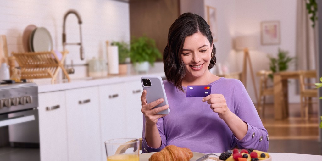 Mujer feliz con su primera tarjeta de crédito Nu. Aplicar a una tarjeta de crédito por primera vez